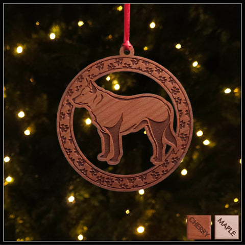 A round cherry wood veneer ornament with a border of small paw prints. The center of the ornament is a blue heeler dog