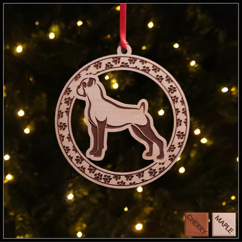 A round maple wood veneer ornament with a border of small paw prints. The center of the ornament is a boxer dog