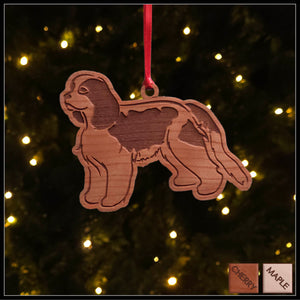 A Cavalier King Charles Spaniel cherry wood veneer ornament, with the dog in profile. 