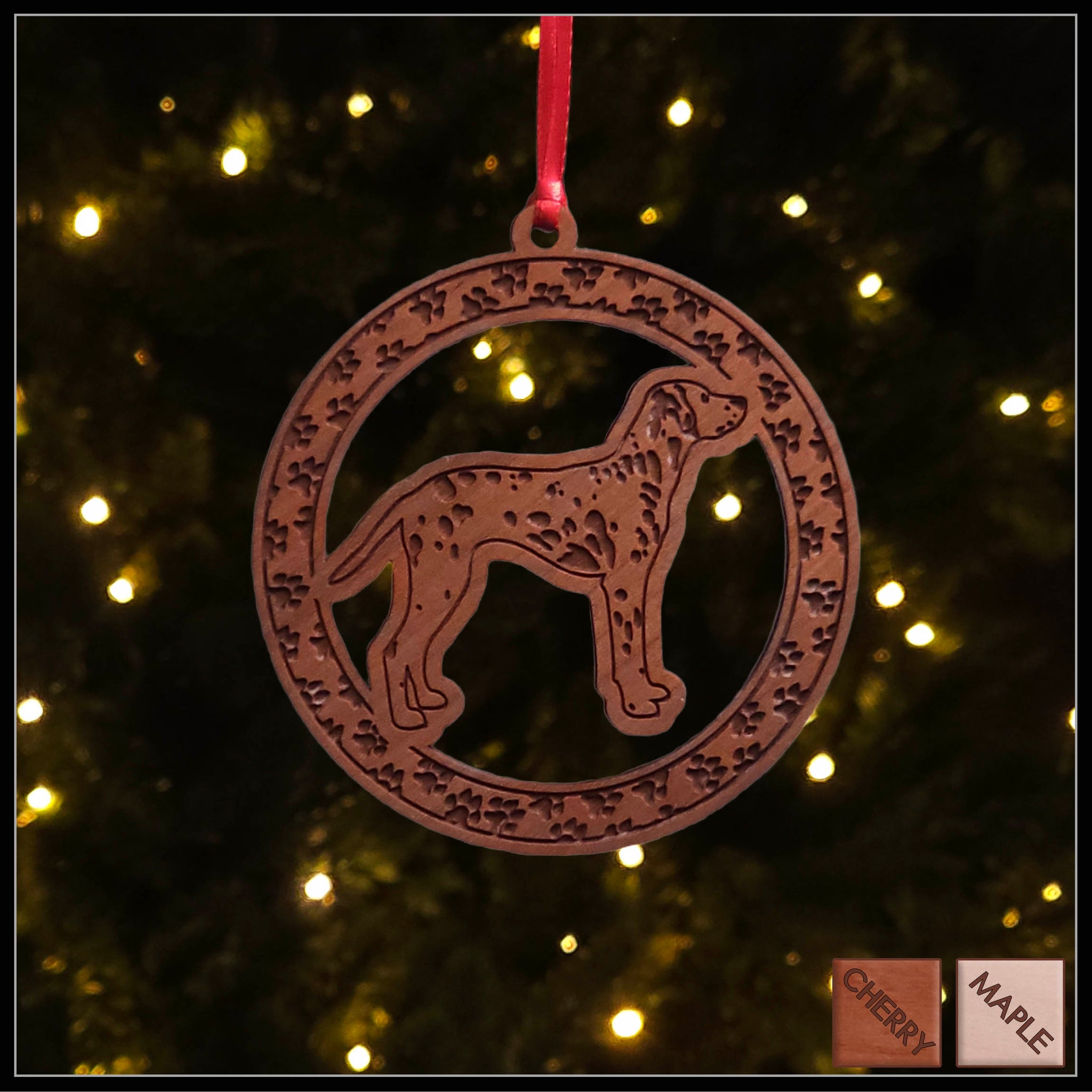 A round cherry wood veneer ornament with a border of small paw prints. The center of the ornament is a Dalmation.