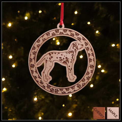 A round maple wood veneer ornament with a border of small paw prints. The center of the ornament is a Dalmation.