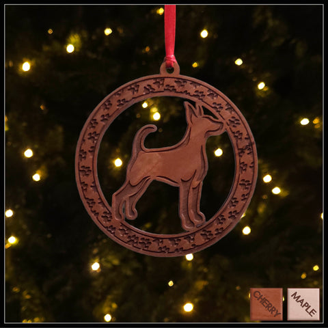 A round cherry wood veneer ornament with a border of small paw prints. The center of the ornament is a Doberman dog.