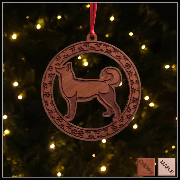 A round cherry wood veneer ornament with a border of small paw prints. The center of the ornament is a Husky dog.