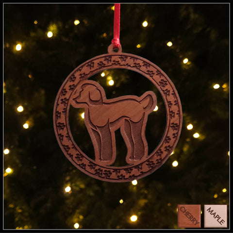 A round cherry wood veneer ornament with a border of small paw prints. The center of the ornament is a Poodle dog.