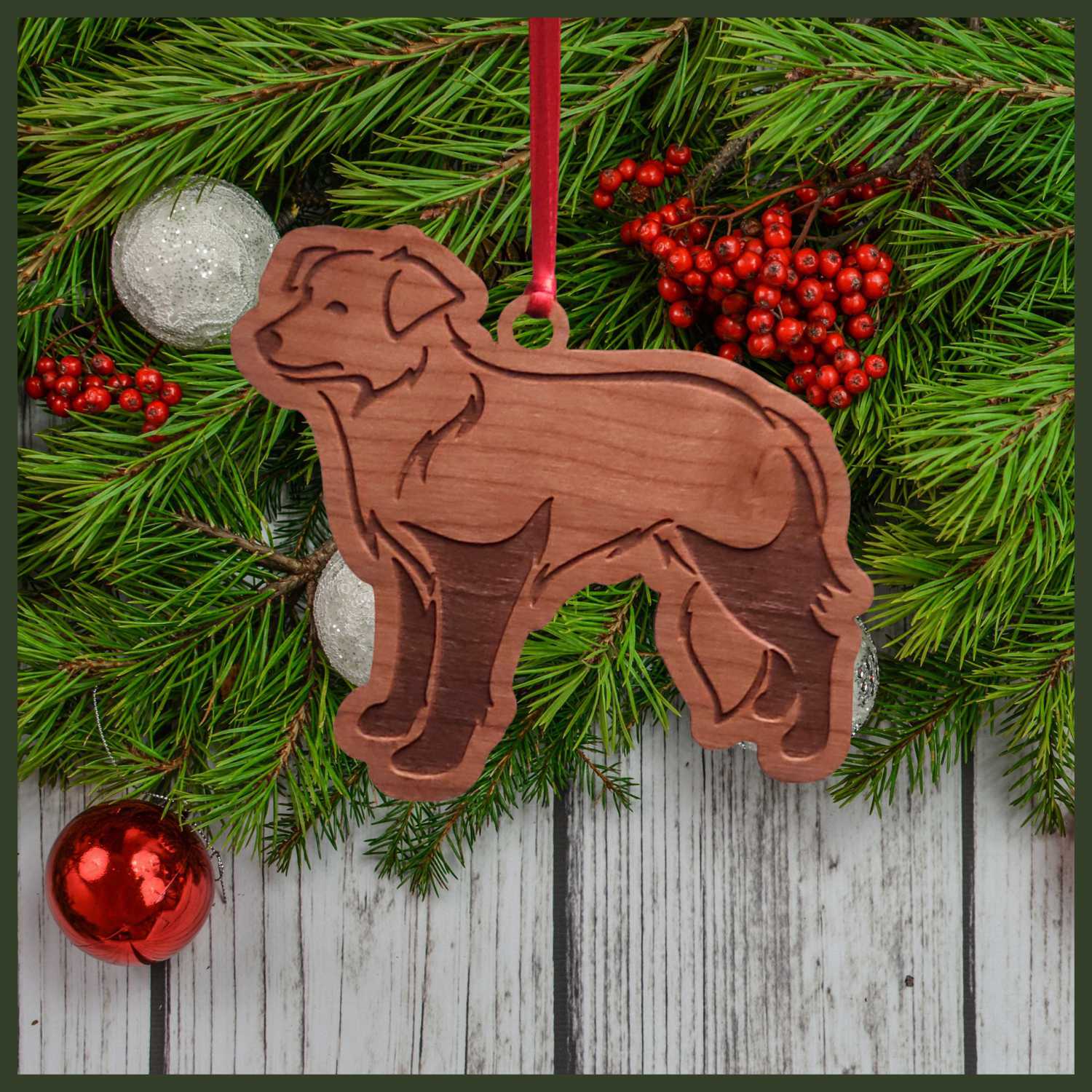 A Border Collie dog cherry wood veneer ornament, with the dog in profile. 