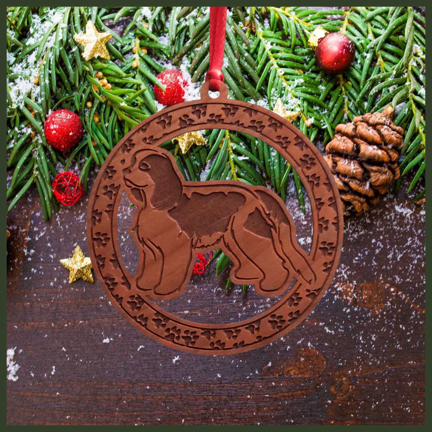 A round cherry wood veneer ornament with a border of small paw prints. The center of the ornament is a Cavalier King Charles dog.