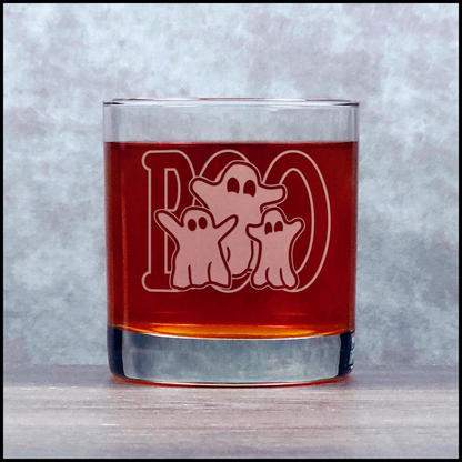 Glass with ghost design and red liquid on a textured surface