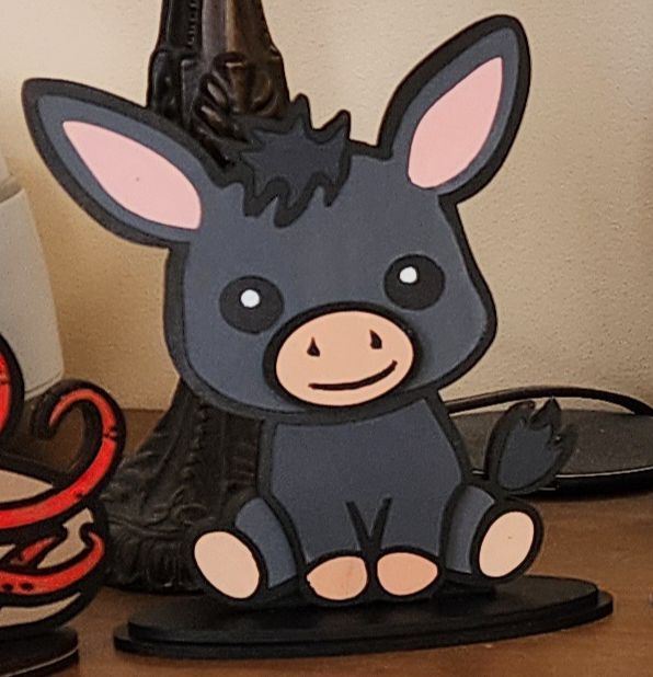 Cartoon donkey shelf decor on a windowsill with a blurred background
