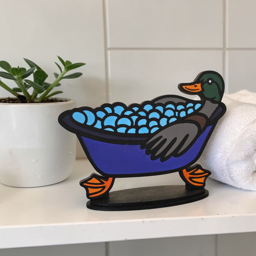 Decorative duck shelf sitter finished kit with bathtub on a shelf next to a plant and towel