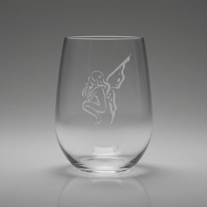 Clear glass with an engraved fairy design on a wooden surface 