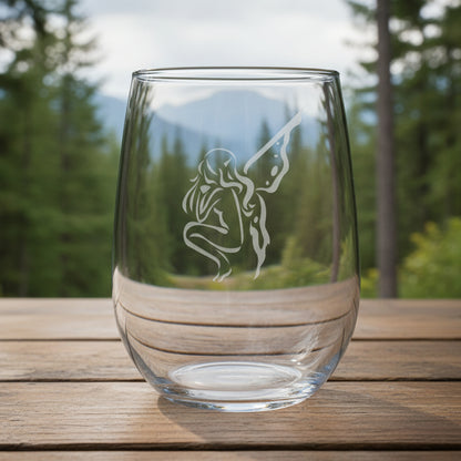 Clear glass with an engraved fairy design on a wooden surface