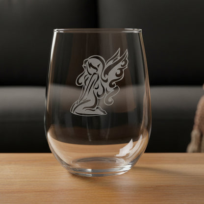 Clear glass with fairy design on a wooden surface and black couch in the background