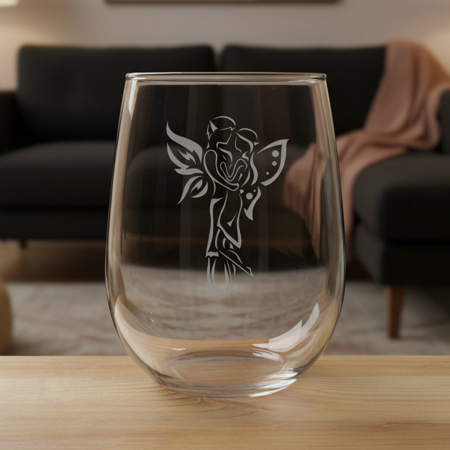 Clear glass with a fairy couple design on a wooden surface and black couch in the  background