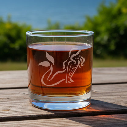 Glass with mermaid design filled with a red liquid 