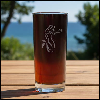 Cooler glass with mermaid design on a Wood surface with the sea in the 
background