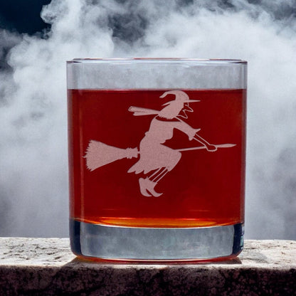 An image of an 11oz whiskey glass with a misty background with a witch on her broomstick.