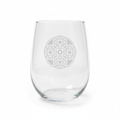 A clear stemless wine glass with a mandala etched design on the front, shown against a plain white background.