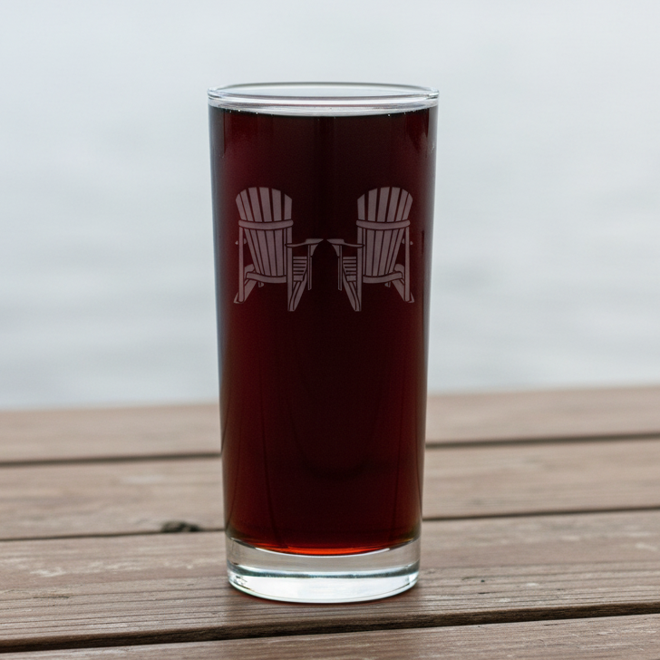Clear glass with red liquid and two Adirondack chairs etched on a cooler glass