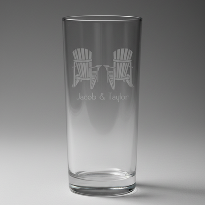 Black pint glass with engraved design of two Adirondack chairs and 'Jacob & Taylor' text on a white background.