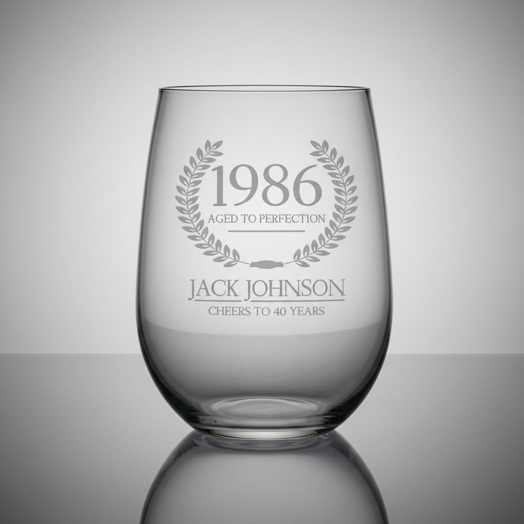 Clear glass with engraved text on a wooden surface and grey background