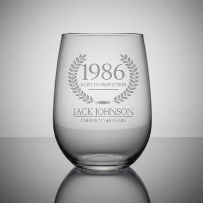 Clear glass with engraved text on a wooden surface and grey background