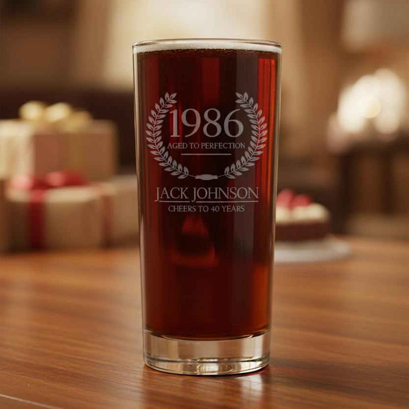 Glass with engraved text '1986 Aged to Perfection Jack Johnson Cheers to 40 Years' on a gray background