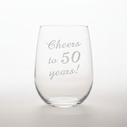 Clear glass stemless wine glass with 'Cheers to 50 years!' engraving on a black background.