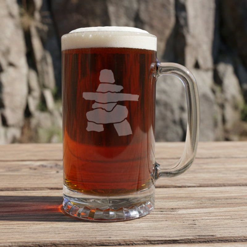 Inuksuk beer mug on a wooden picnic table with a rock face behind it