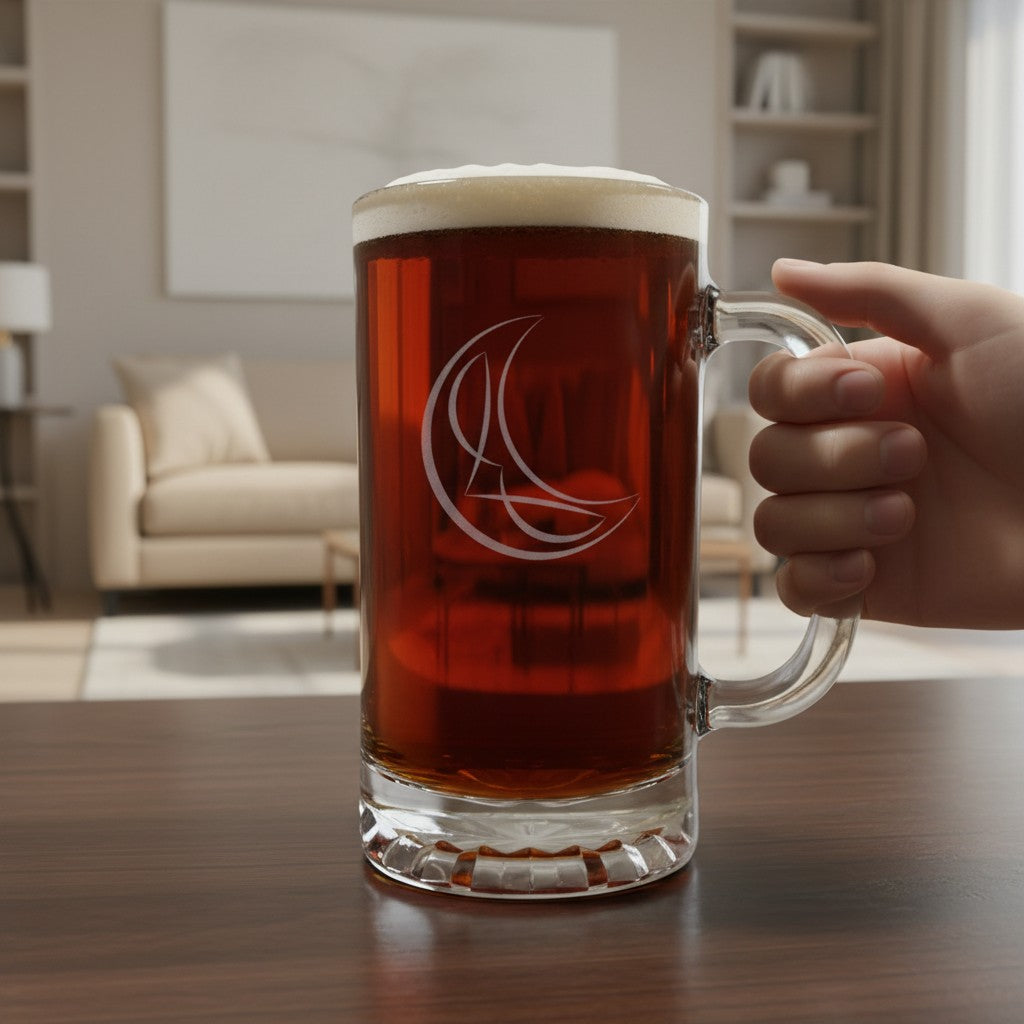 A large clear glass beer mug filled with amber beer and topped with white foam, held by a hand on a wooden table in a blurred living room setting. The mug has a white etched crescent design.