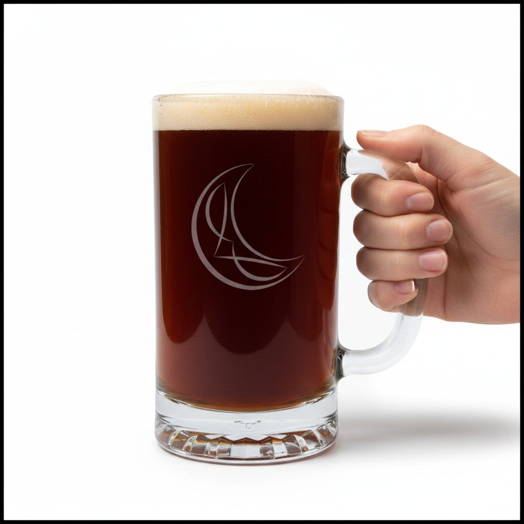 A hand holding a clear glass beer mug filled with dark beer and topped with foam, featuring an etched crescent moon and star logo on the front, set against a plain white background.