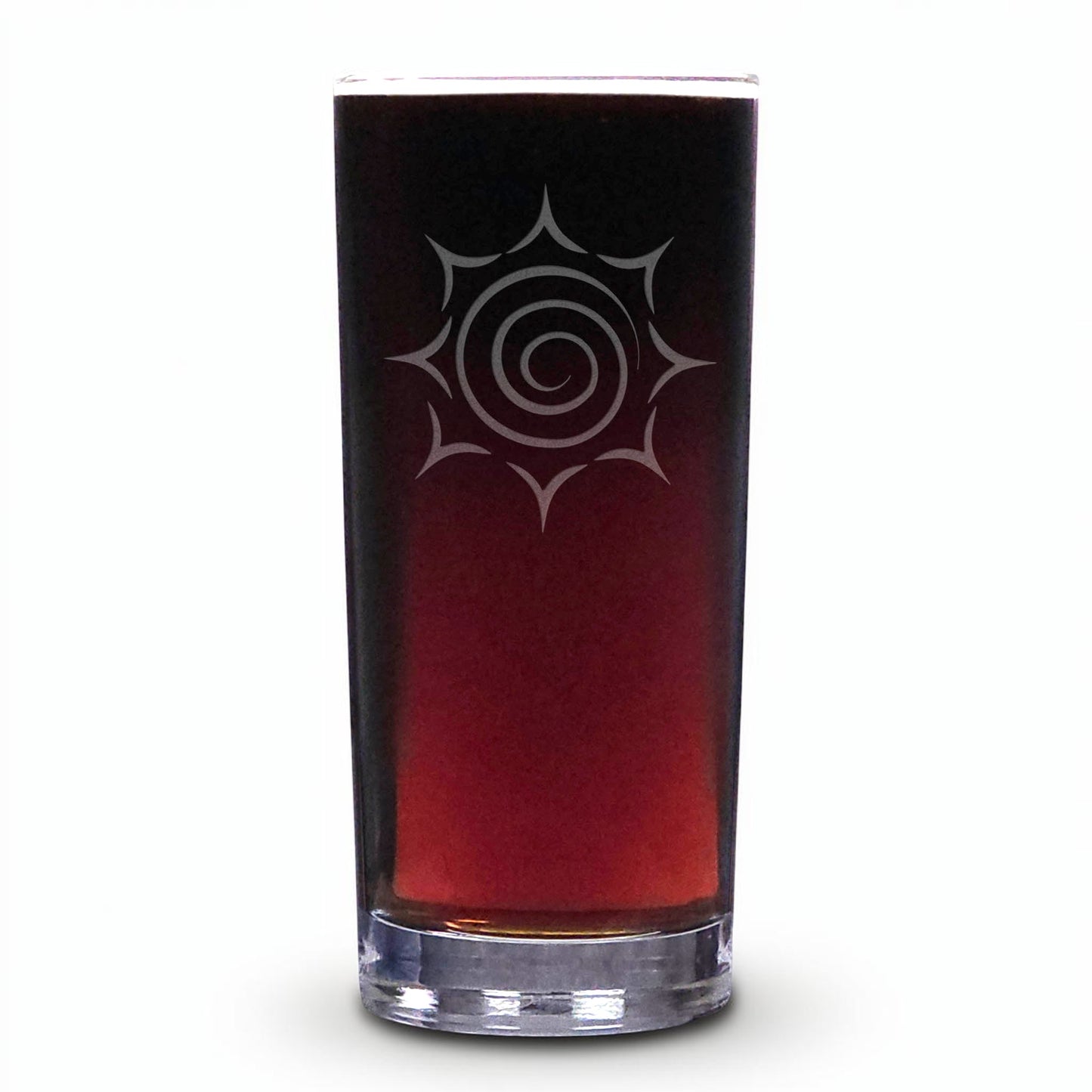 A tall, slender clear glass tumbler filled with a dark reddish-brown liquid, featuring a white etched spiral sunburst design on the front, set against a plain white background.