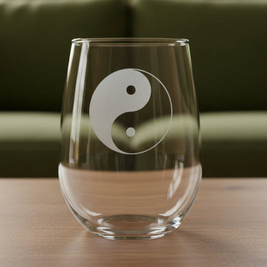 Clear glass with engraved Yin Yang design and 'Matthew' text on a wooden surface.