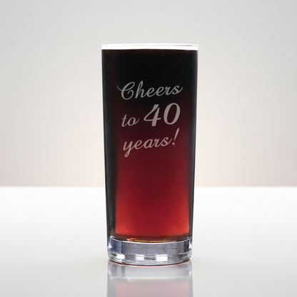 Glass with red liquid and 'Cheers to 40 years!' text on a white background