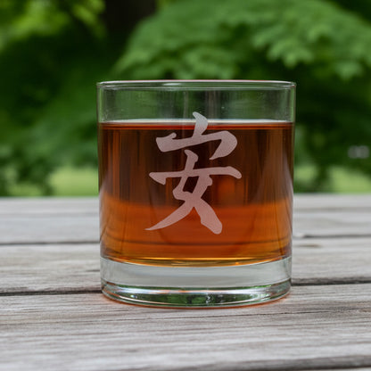 Glass with amber liquid and a Kanji symbol for Tranquility with a tree in background