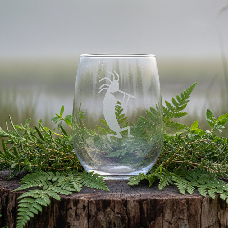 Clear glass on a Log with greenery with a background of a misty lake.