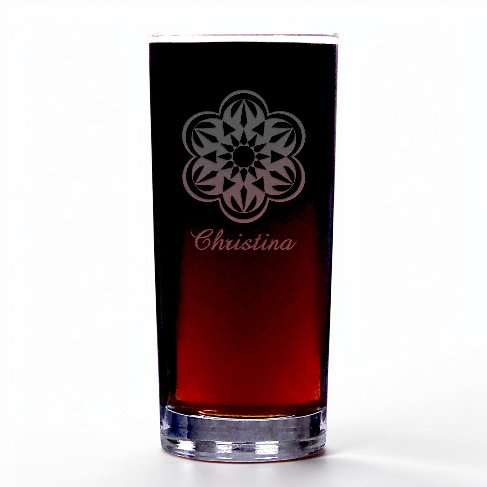 A clear highball glass with a dark red liquid inside, featuring an etched floral mandala design and the name 'Christina' in cursive near the top. The glass is photographed on a clean white background.