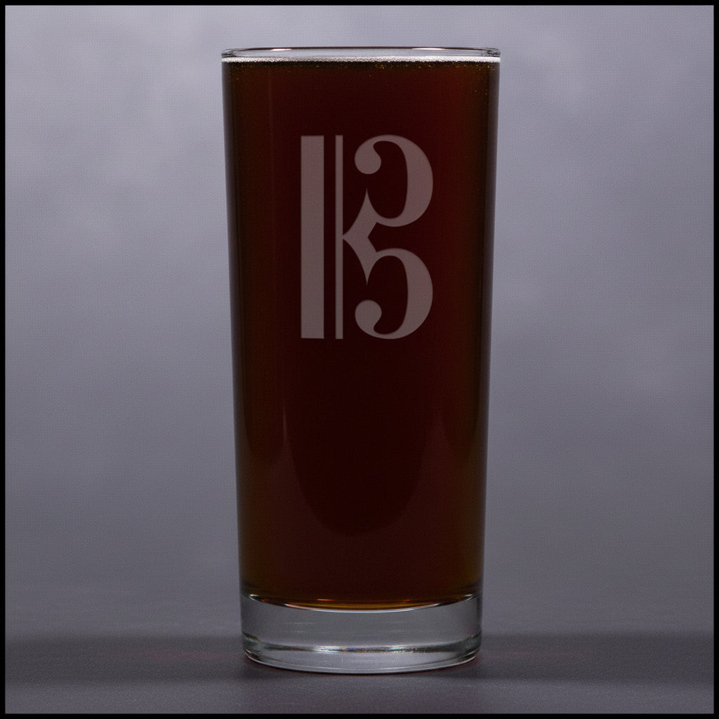 Cooler glass with a alto clef etching on a gray background