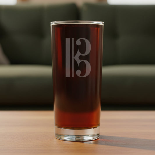 Cooler glass with a alto clef etching with a green couch behind glass