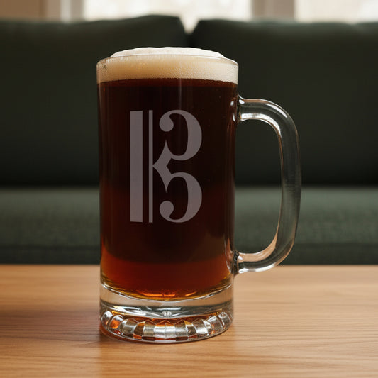 Glass mug with a alto clef engraving filled with dark beer on a wooden surface with a green couch in the background