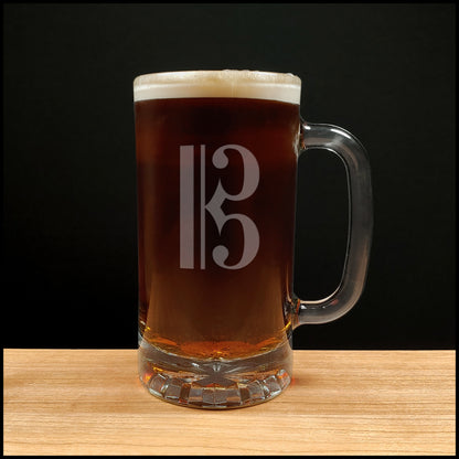 Glass mug with a treble clef engraving filled with dark beer on a wooden surface 