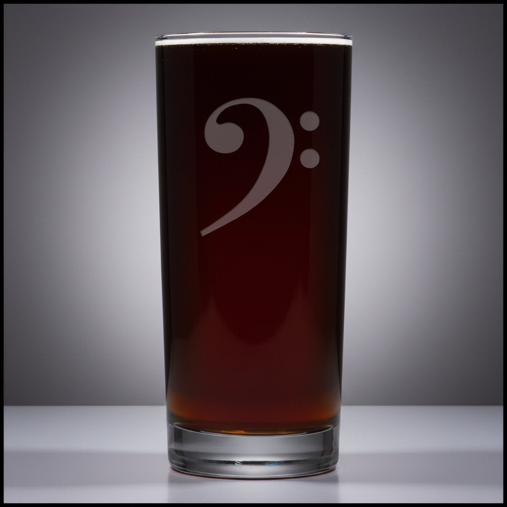 Cooler glass mug with a bass clef engraving filled on a grey surface 