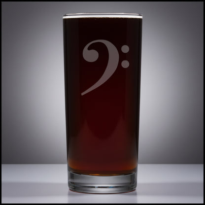 Cooler glass mug with a bass clef engraving filled on a grey surface 