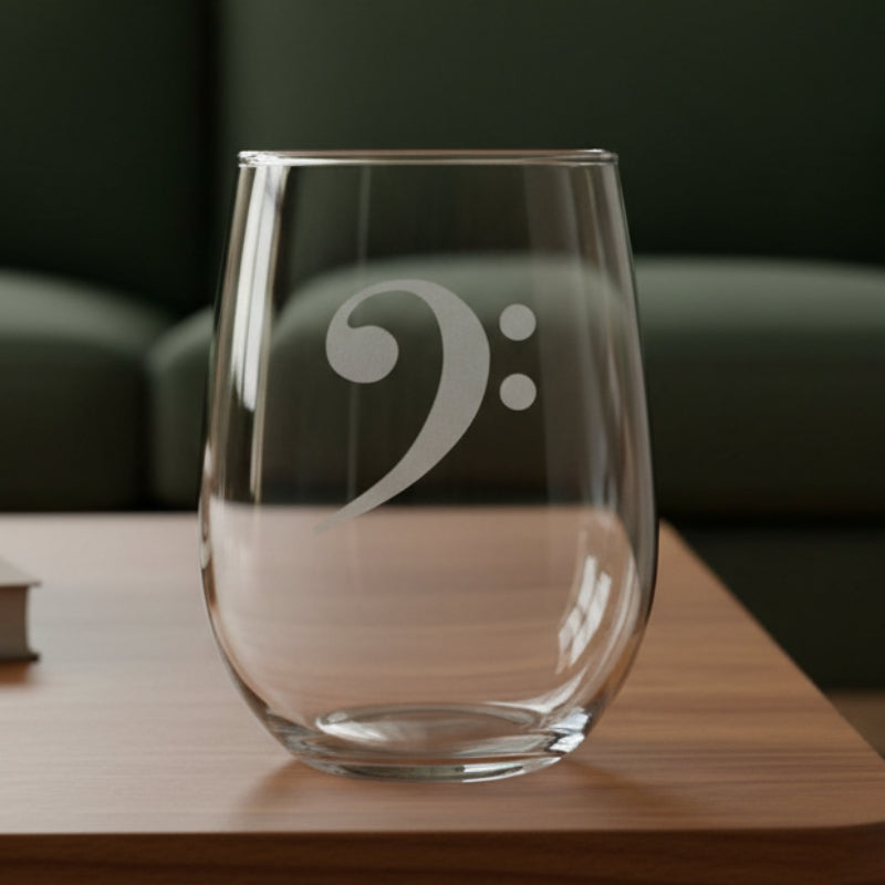 Bass Clef stemless wine glass with a green couch behind it