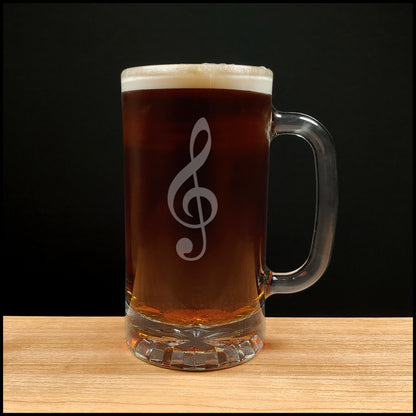 Glass mug with a treble clef engraving filled with dark beer on a wooden surface 