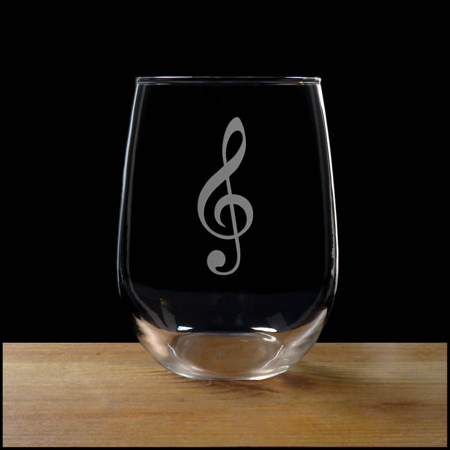 Treble Clef with Heart stemless wine glass on a wood surface with a black background