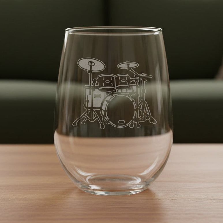 Drum Set stemless wine glass with a green couch behind it