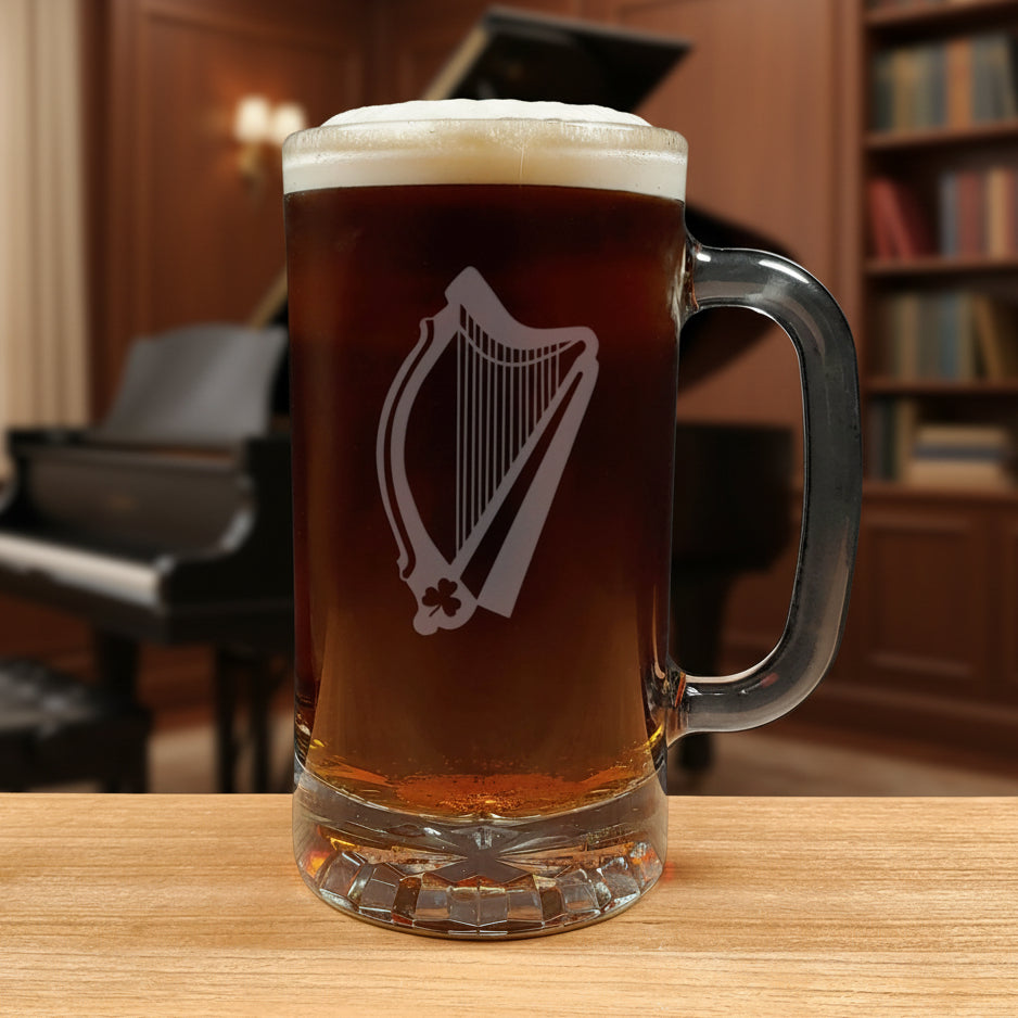 Glass mug with a harp engraving filled with dark beer on a wooden surface with a music room in the background