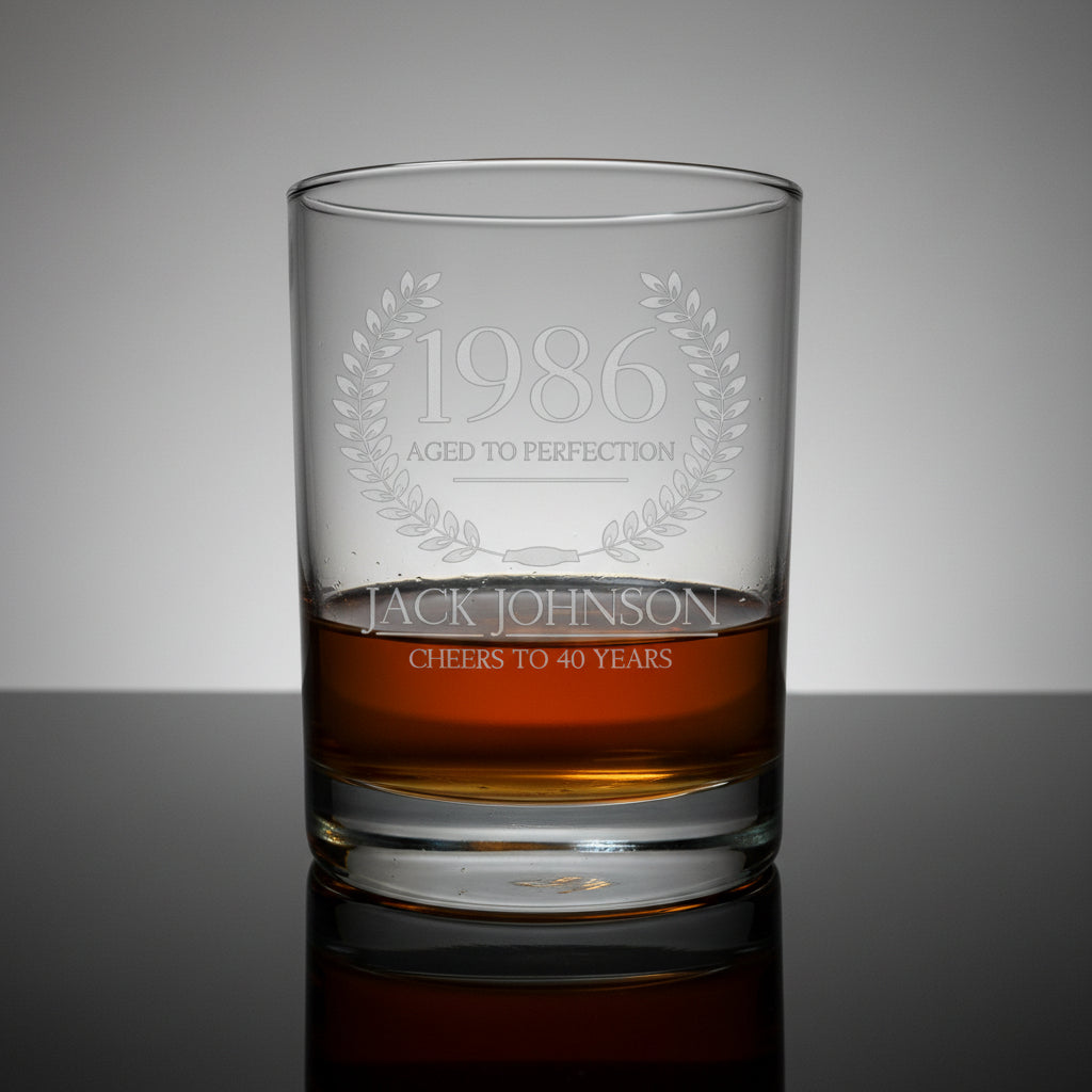 Whiskey glass with engraved text '1986 Aged to Perfection' and 'Jack Johnson Cheers to 40 Years' 