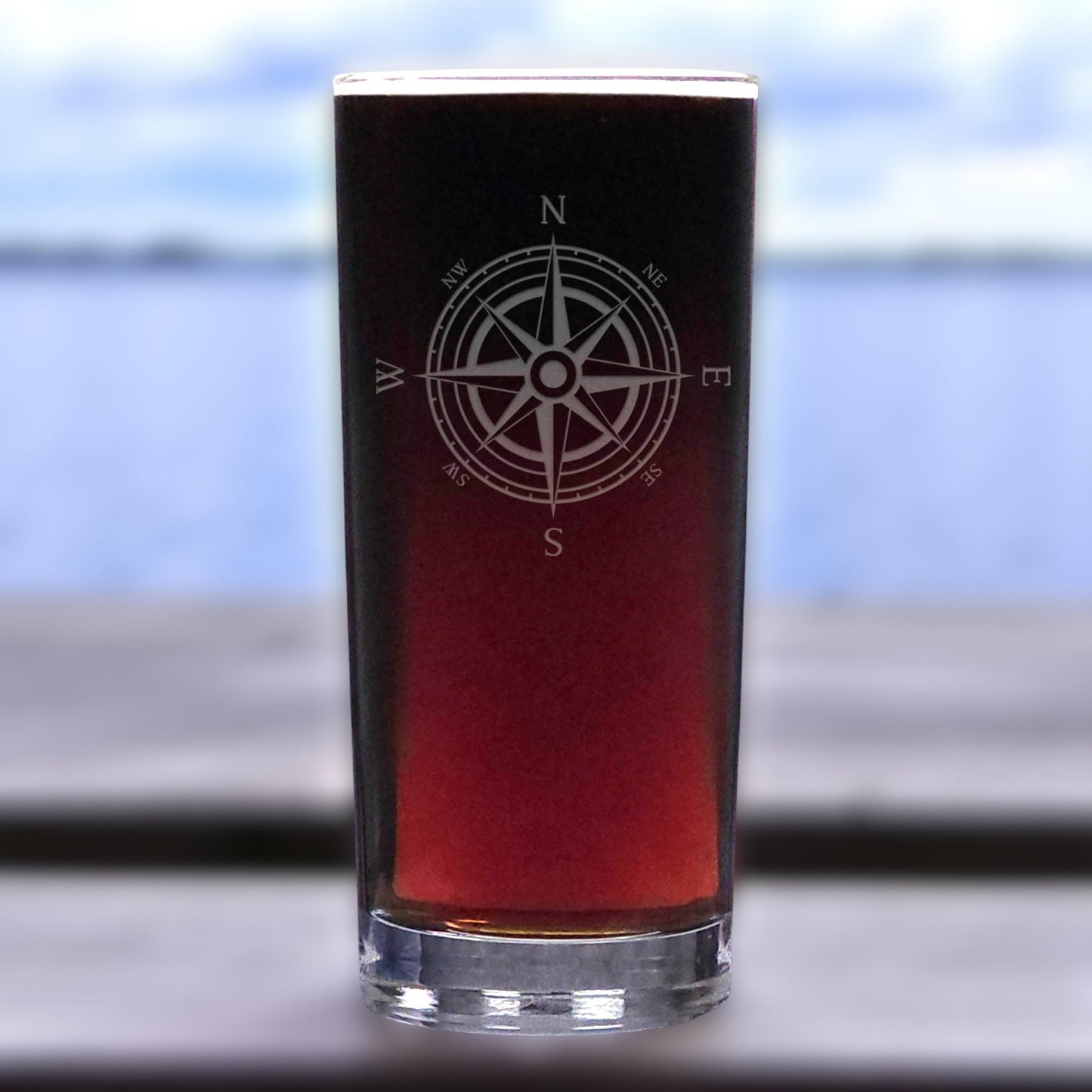 Glass with a compass design on a blurred outdoor background