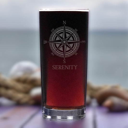Glass with compass design and 'Serenity' text on a blurred background